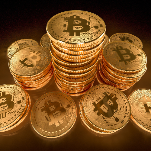 Stacks of golden Bitcoin coins with the Bitcoin symbol, representing cryptocurrency and digital wealth